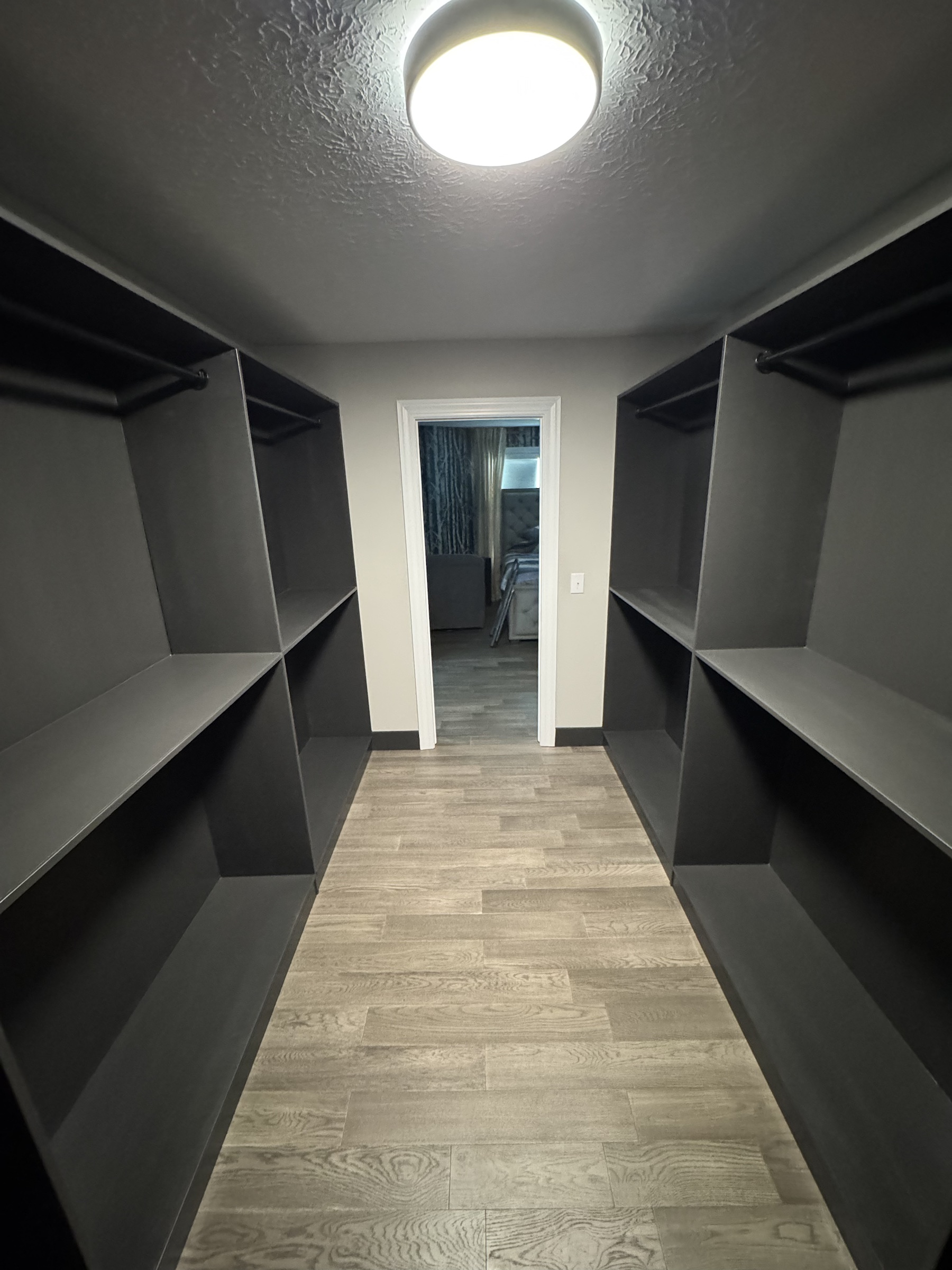 Completed custom closet with dark painted built-ins