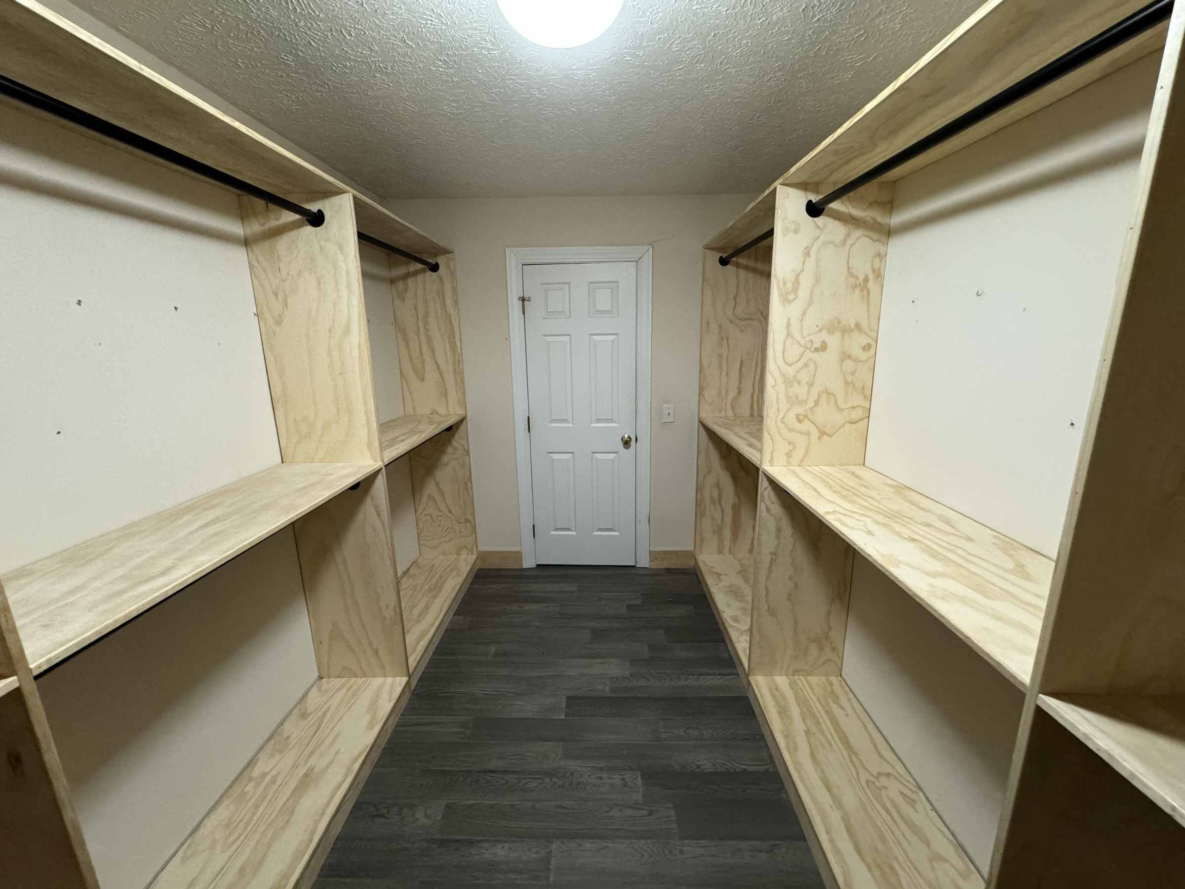 Unfinished plywood closet shelving before painting
